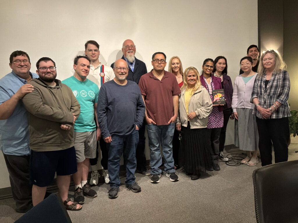 Group of 14 people looking foward and smiling.